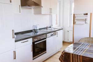 a white kitchen with a sink and a stove at Ferienwohnung an der Berliner Seenkette in Schwerin