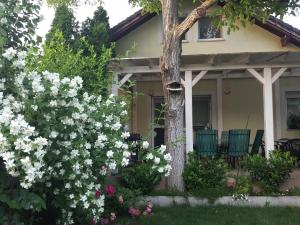 a house with white flowers and a tree at Tavirózsa in Balatonfůzfő