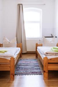 two beds in a room with a window and a rug at Ferienwohnung an der Berliner Seenkette in Schwerin