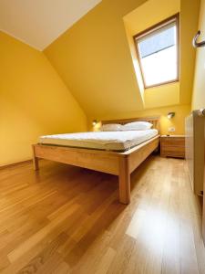 ein Schlafzimmer mit einem Bett in einem gelben Zimmer in der Unterkunft Apartma Idila in Zreče