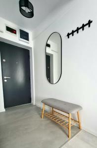 uno specchio e una panca davanti a una porta di Dolphin Apartment near Neversea Beach a Constanţa