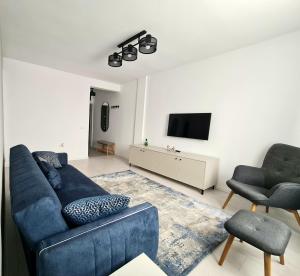 a living room with a blue couch and a tv at Dolphin Apartment near Neversea Beach in Constanţa