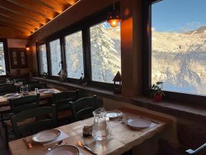 a restaurant with tables and chairs and a view of a mountain at Casa Benassi Room&breakfast in Riolunato