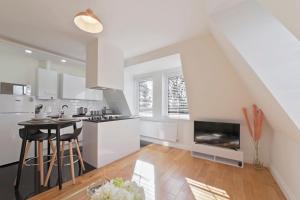 a white kitchen with a table and a fireplace at Spacious One Bed loft Apartment in Birchanger