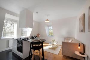 a kitchen with a stove and a table in a room at Spacious One Bed loft Apartment in Birchanger