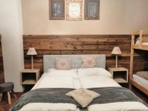 um quarto com uma cama com lençóis brancos e almofadas cor-de-rosa em Casa Benassi Rooms, Apartament & Suite con Piscina panoramica e Wellness em Riolunato