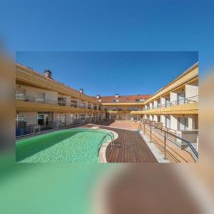 a building with a swimming pool in front of it at Apartamentos turísticos CHUS 2 in Corcubión