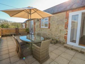 a table and chairs with an umbrella on a patio at Parlour Cottage in Newport