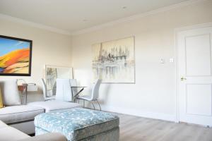 a living room with a couch and a table at Spacious and Stylish 1 Bedroom Flat near Chelsea in London