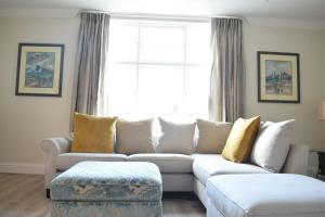 a living room with a white couch and a window at Spacious and Stylish 1 Bedroom Flat near Chelsea in London