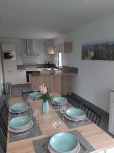 a dining room table with plates and wine glasses at Maison TY PRAD bord de mer in Sarzeau +4 photos