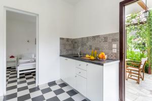 eine Küche mit weißen Schränken und einem Schachbrettmusterboden in der Unterkunft Ageri Studios in Stafylos + 42 Fotos