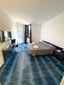 a room with a bed and a desk and a laptop at Hotel San Paolo in Palinuro