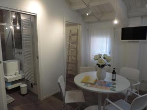 mały pokój ze stołem i wazą kwiatów w obiekcie Al Sagraeto White apartment w mieście Chioggia +20 zdjęć