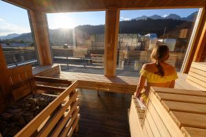 Una mujer con un vestido amarillo está mirando por la ventana de una iglesia. en Hotel Planai by Alpeffect Hotels en Schladming