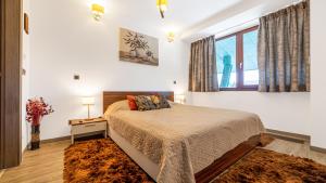 a bedroom with a bed and a large window at Harmony Apartment in Silver Mountain in Poiana Brasov +40 photos