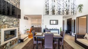 a kitchen and living room with a table and a fireplace at Harmony Apartment in Silver Mountain in Poiana Brasov