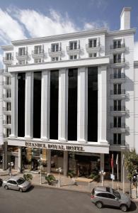 un grande edificio bianco con macchine parcheggiate di fronte di Istanbul Royal Hotel a Istanbul