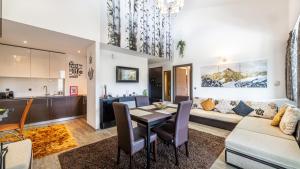 a kitchen and living room with a table and a couch at Harmony Apartment in Silver Mountain in Poiana Brasov