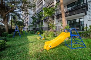 een tuin met speeltoestellen voor een gebouw bij Manhattan Pattaya Hotel - SHA Extra Plus in Noord Pattaya