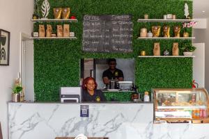 a woman sitting at the counter of a restaurant at The Avery Apartments at Odomaa Place, East Airport in Accra