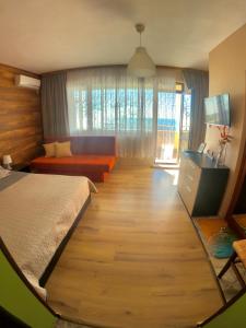 a bedroom with a large bed and a wooden floor at Sunset Yavorov Pomorie in Pomorie