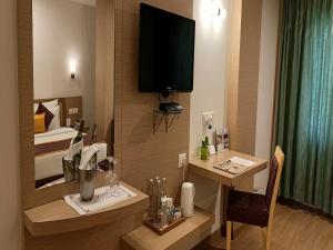 una camera d'albergo con una scrivania e una televisione a parete di IRA By Orchid Bhubaneswar a Bhubaneshwar
