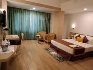 una camera d'albergo con un letto, una scrivania e una stanza di IRA By Orchid Bhubaneswar a Bhubaneshwar