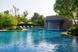 een zwembad met een waterval in een tuin bij Manhattan Pattaya Hotel - SHA Extra Plus in Noord Pattaya