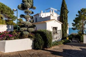 una casa blanca con árboles y flores en una calle en Cau del Llop 76 apartamento piscina comunitaria en Girona