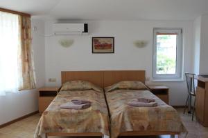 a bedroom with a bed with two pillows on it at Hotel Radik in Sozopol