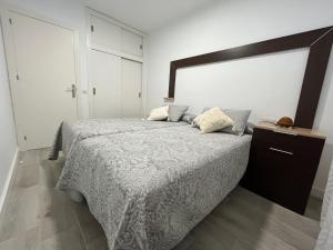 1 dormitorio con 1 cama grande y cabecero de madera en TAO 1 Primera línea de Playa VELILLA, en Almuñécar