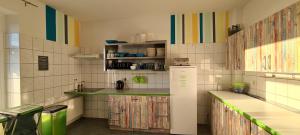 uma cozinha com riscas coloridas na parede e um frigorífico em Harz Hostel em Wernigerode