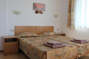 1 dormitorio con 1 cama grande y toallas. en Hotel Radik en Sozopol