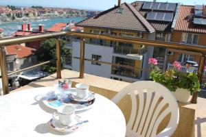 a table and chairs on a balcony with a view at Hotel Radik in Sozopol