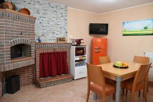 eine Küche mit einem Tisch und einem gemauerten Kamin in der Unterkunft Locazione Turistica Arcobaleno "Appartamento Superior" in Roccavivara