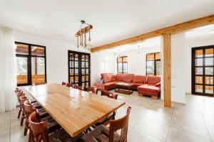 a dining room with a large wooden table and chairs at Pensiunea Roua Apuseni Belis in Beliş