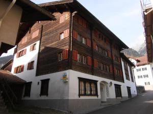 a large wooden building with windows on a street at Casa Job - Gasthaus - Sauna, Whirlpool - Trun in Trun