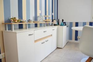 a kitchen with white cabinets and a table at B&B Campitur in Campomarino