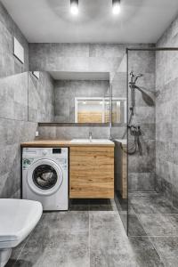 ein Badezimmer mit einer Waschmaschine und einem Waschbecken in der Unterkunft Primo III by LookAp Centrum Dworzec Fabryczny FV in Łódź