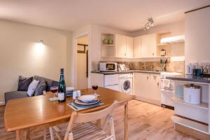 a kitchen and living room with a wooden table and chairs at The Woodshed Benhall Air Manage Suffolk in Saxmundham
