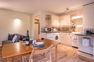 a kitchen and living room with a wooden table and chairs at The Woodshed, Benhall in Saxmundham