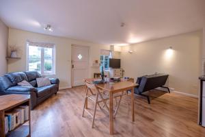 a living room with a couch and a table at The Woodshed, Benhall in Saxmundham +7 photos