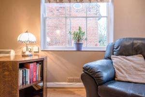 a leather chair in a living room with a window at The Woodshed, Benhall in Saxmundham