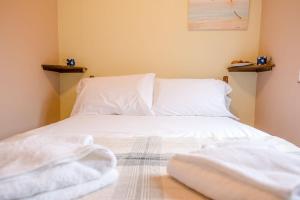 1 dormitorio con sábanas blancas y almohadas en una cama en The Woodshed Benhall Air Manage Suffolk, en Saxmundham