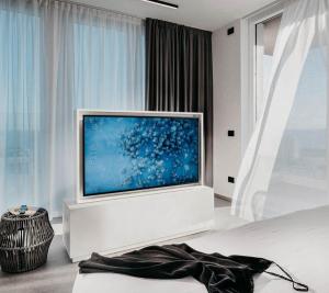 sala de estar con TV de pantalla plana grande en J44 Lifestyle Hotel, en Lido di Jesolo