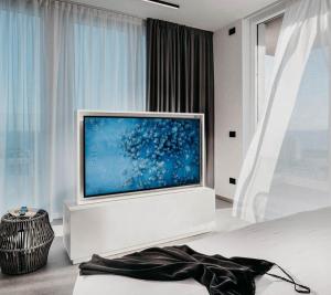 ein Wohnzimmer mit einem großen Flachbild-TV in der Unterkunft J44 Lifestyle Hotel in Lido di Jesolo