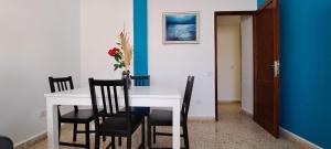 Molinos II - Casitas Las Abuelas في سانتا كروث دي لا بالما: غرفة طعام مع طاولة بيضاء وكراسي