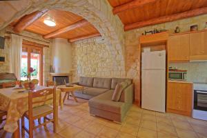 uma cozinha e sala de estar com um sofá e um frigorífico em Villa Nipos by PosarelliVillas em Vryses