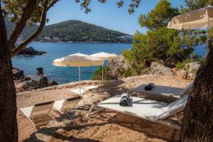 a group of chairs and umbrellas on a beach at Royal Princess Hotel in Dubrovnik